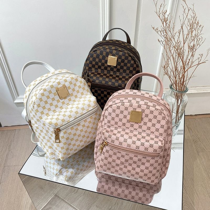 Mini-sacs à dos pour femmes en cuir PU sont disponibles en trois couleurs avec un motif imprimé classique et une plaque dorée.
